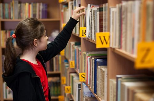 girl in library picking out book